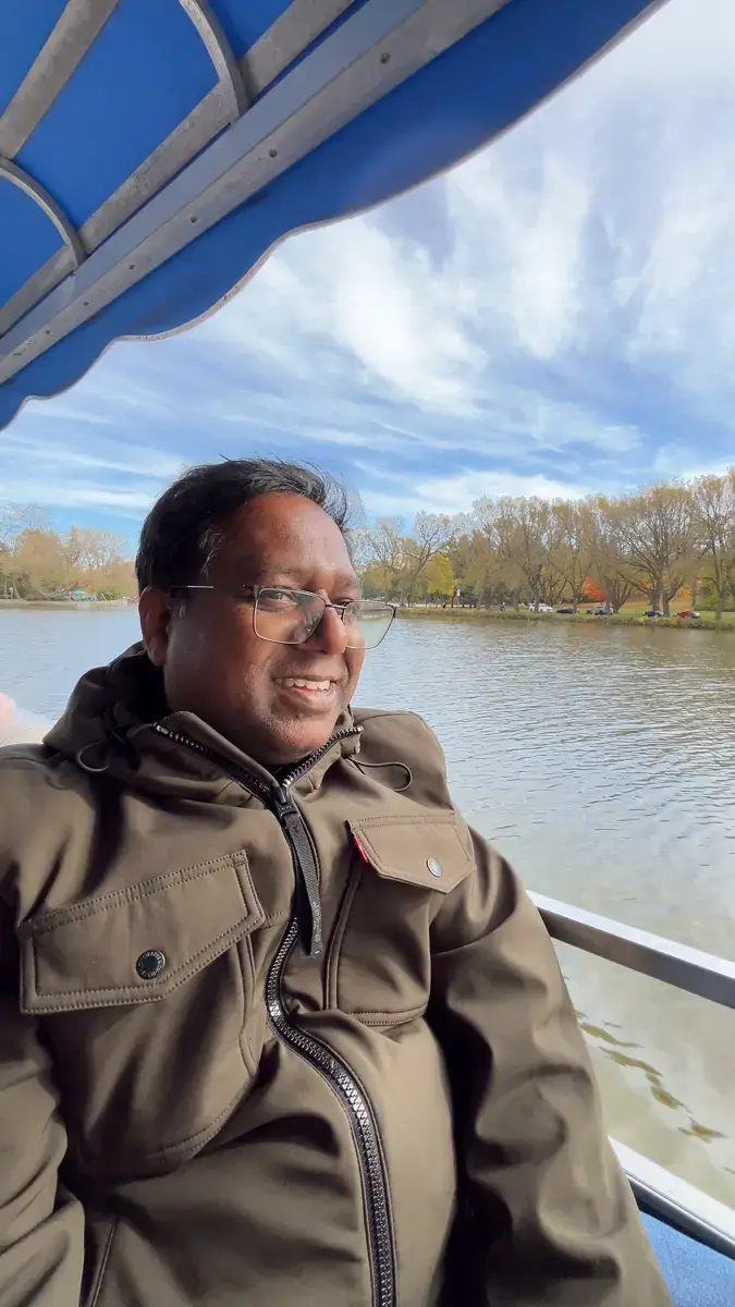 Gopi smiling on a covered river boat on the Avon River