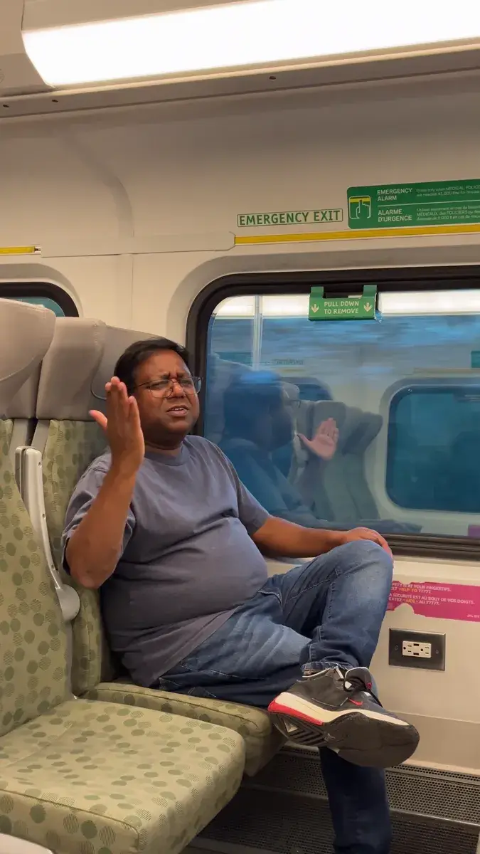 Gopi relaxing in a window seat on the GO train, chatting with friends