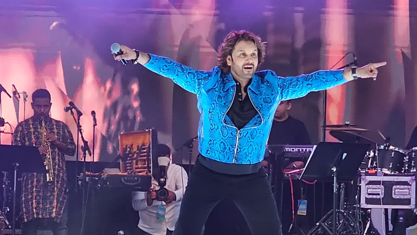 Javed Ali singing with arms wide open on the main stage