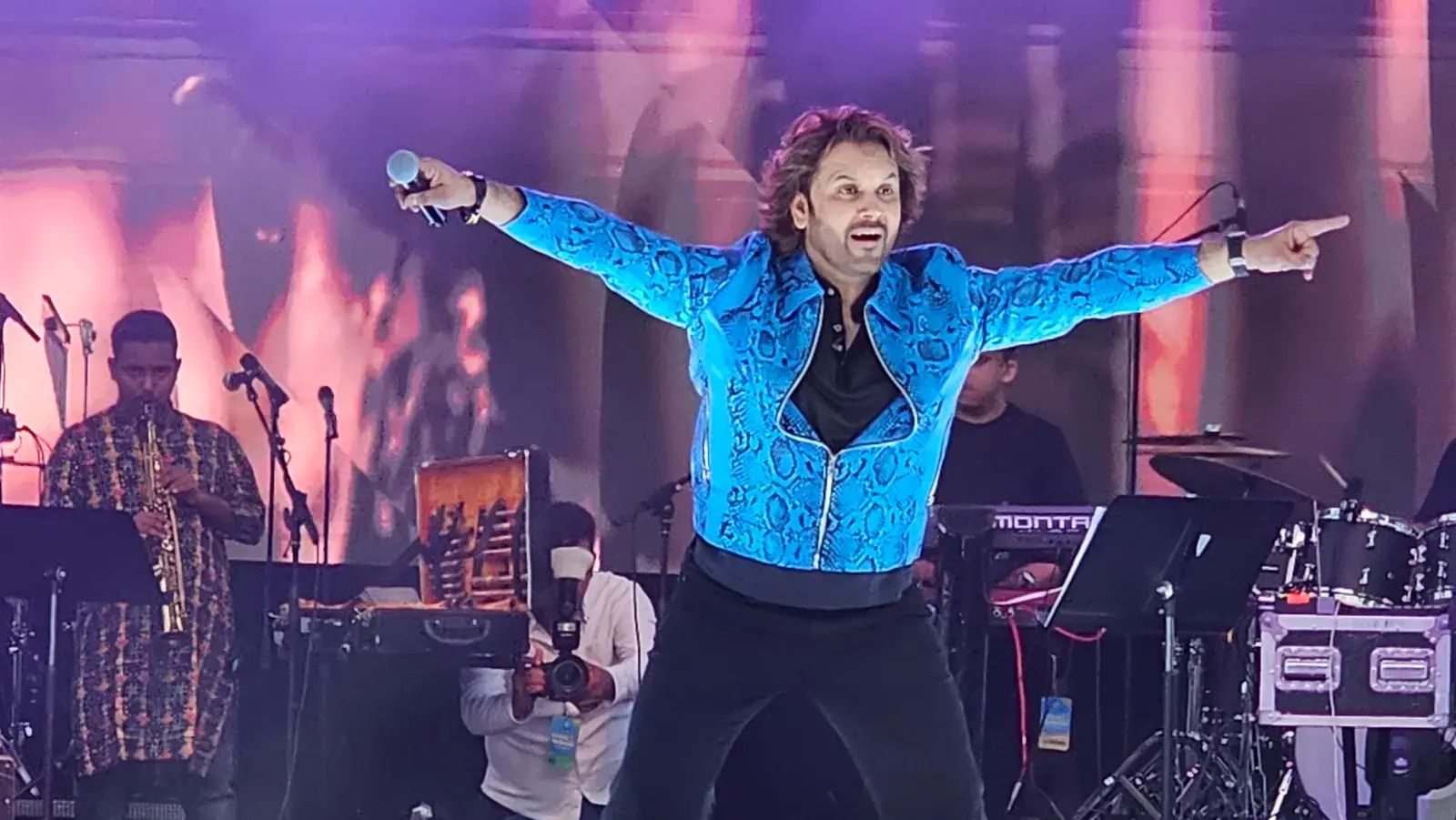 Javed Ali singing with arms wide open on the main stage