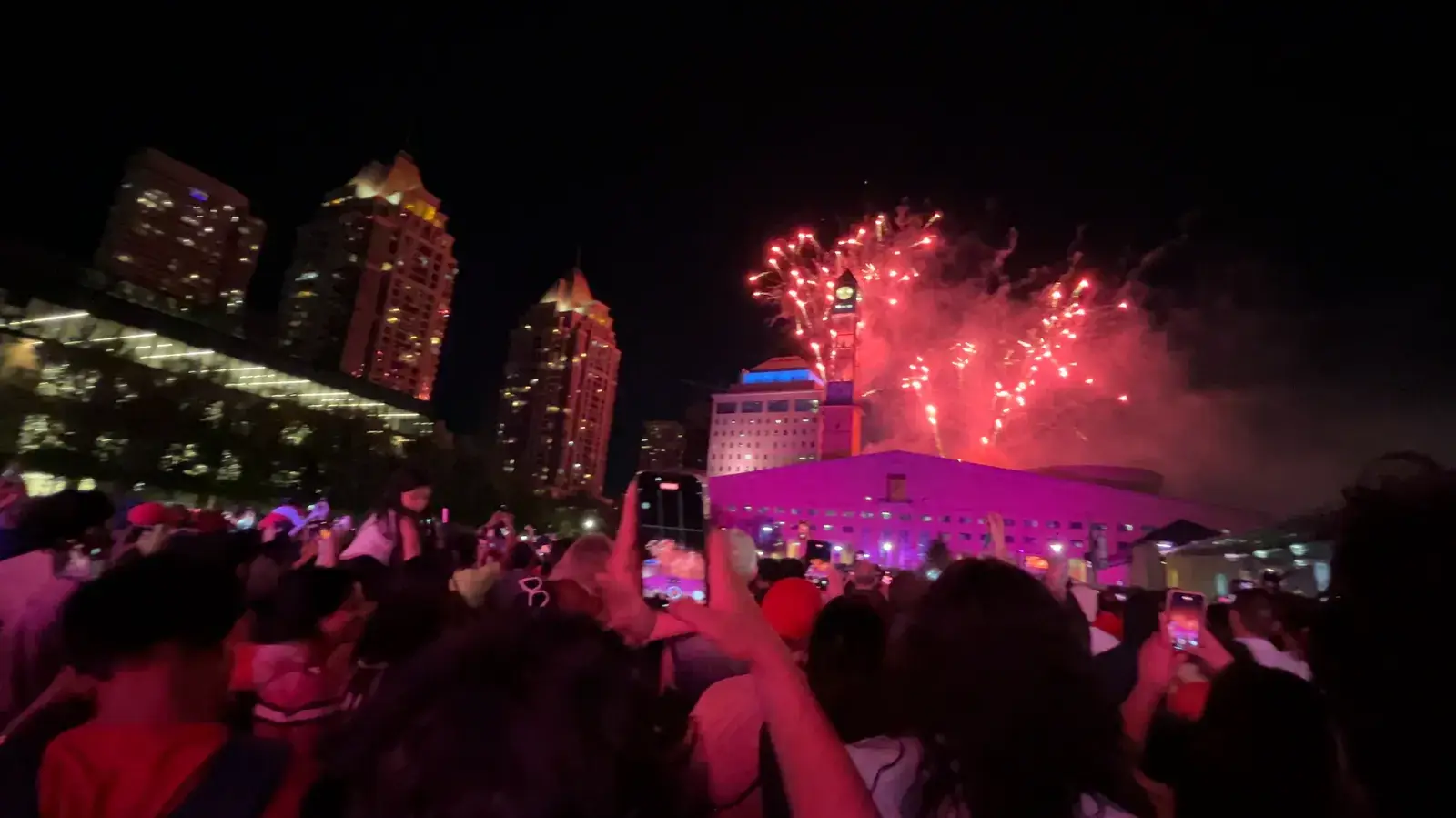 Fireworks bursting over the crowd and towers on New Year's Eve