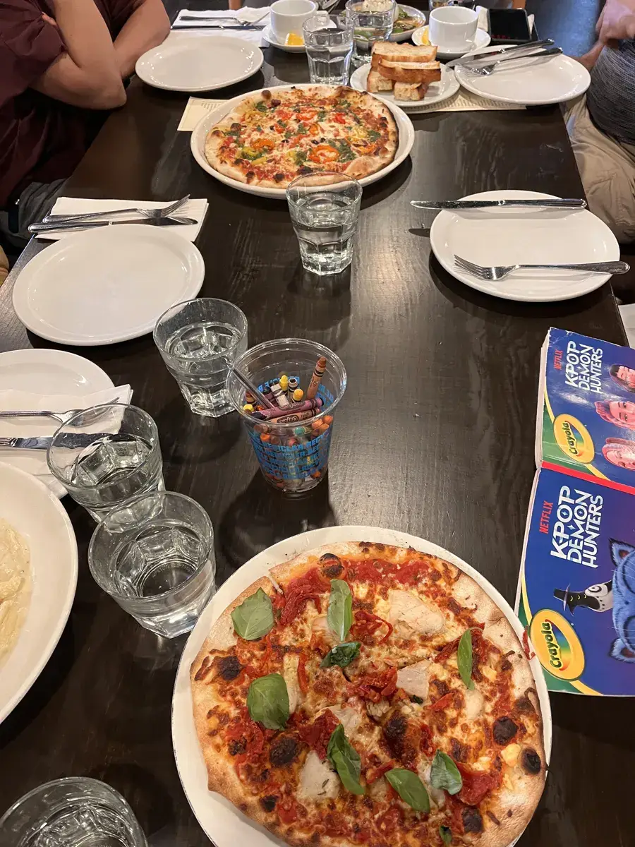 Pizzas and pasta on a long table at Pazzo in Stratford
